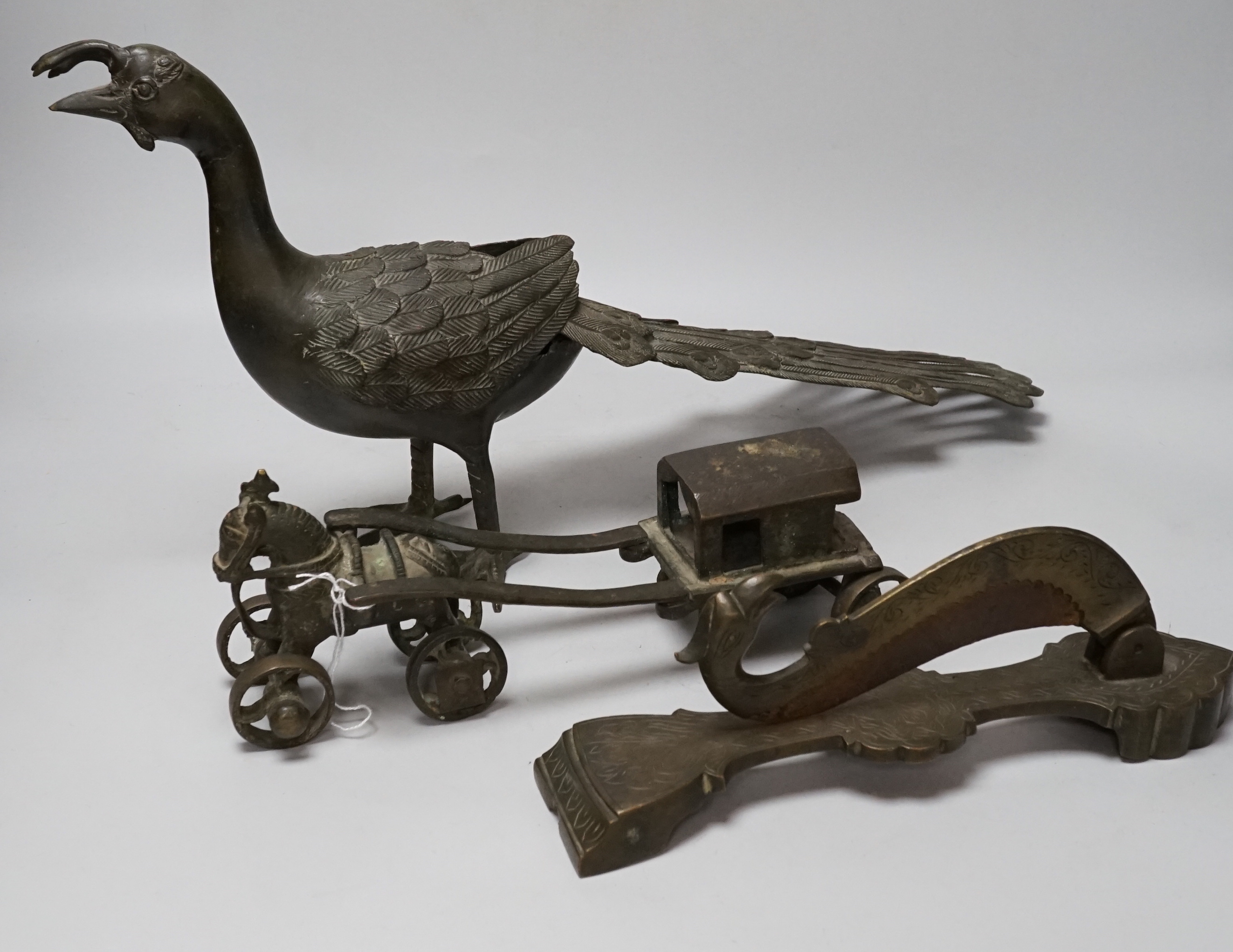 An Indian bronze horse and wagon (lacking one axle), an Indian bronze betel nut cutter and Indian bronze peacock, largest 53cm wide (3)